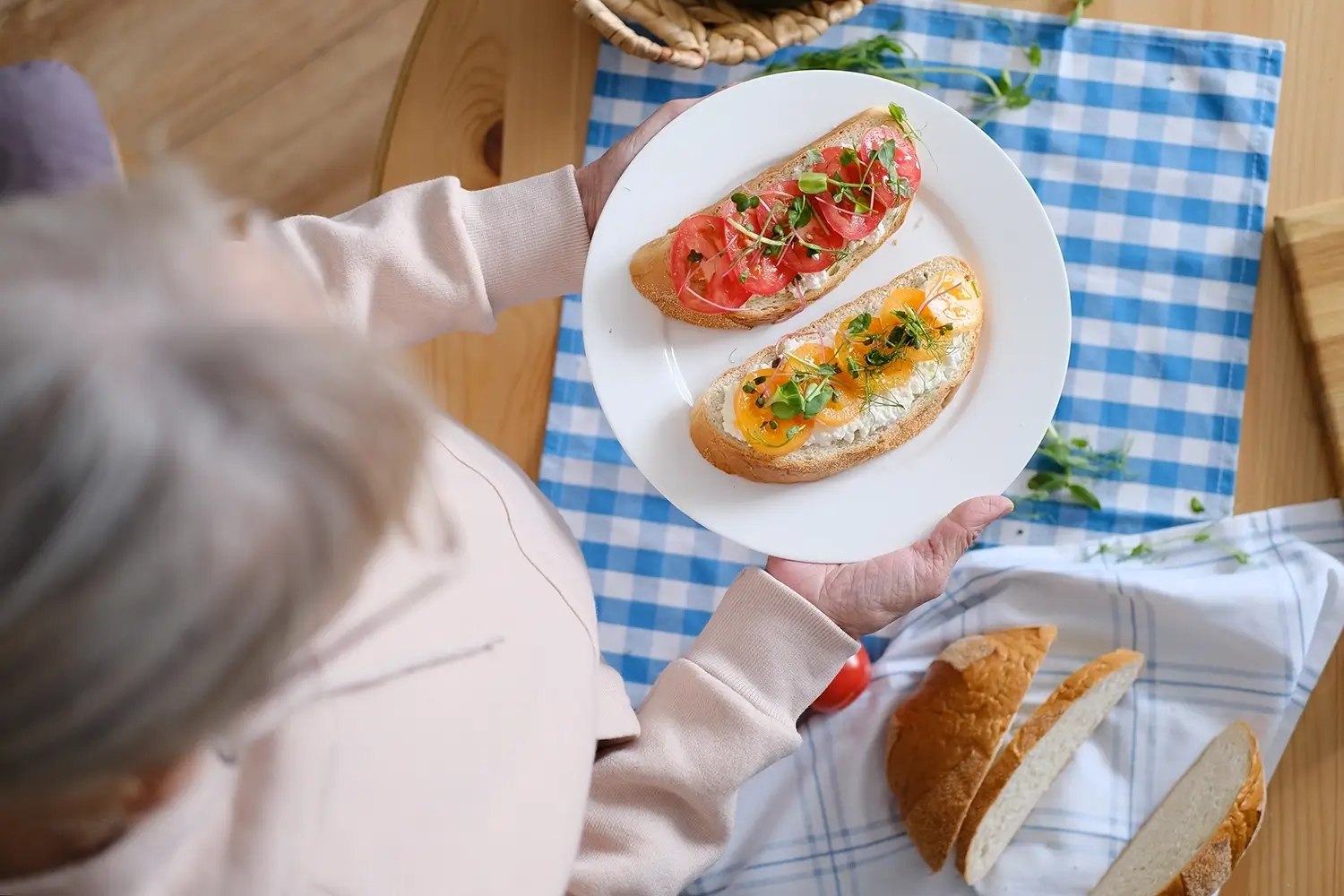 Eine Person hält einen Teller mit zwei offenen Sandwiches