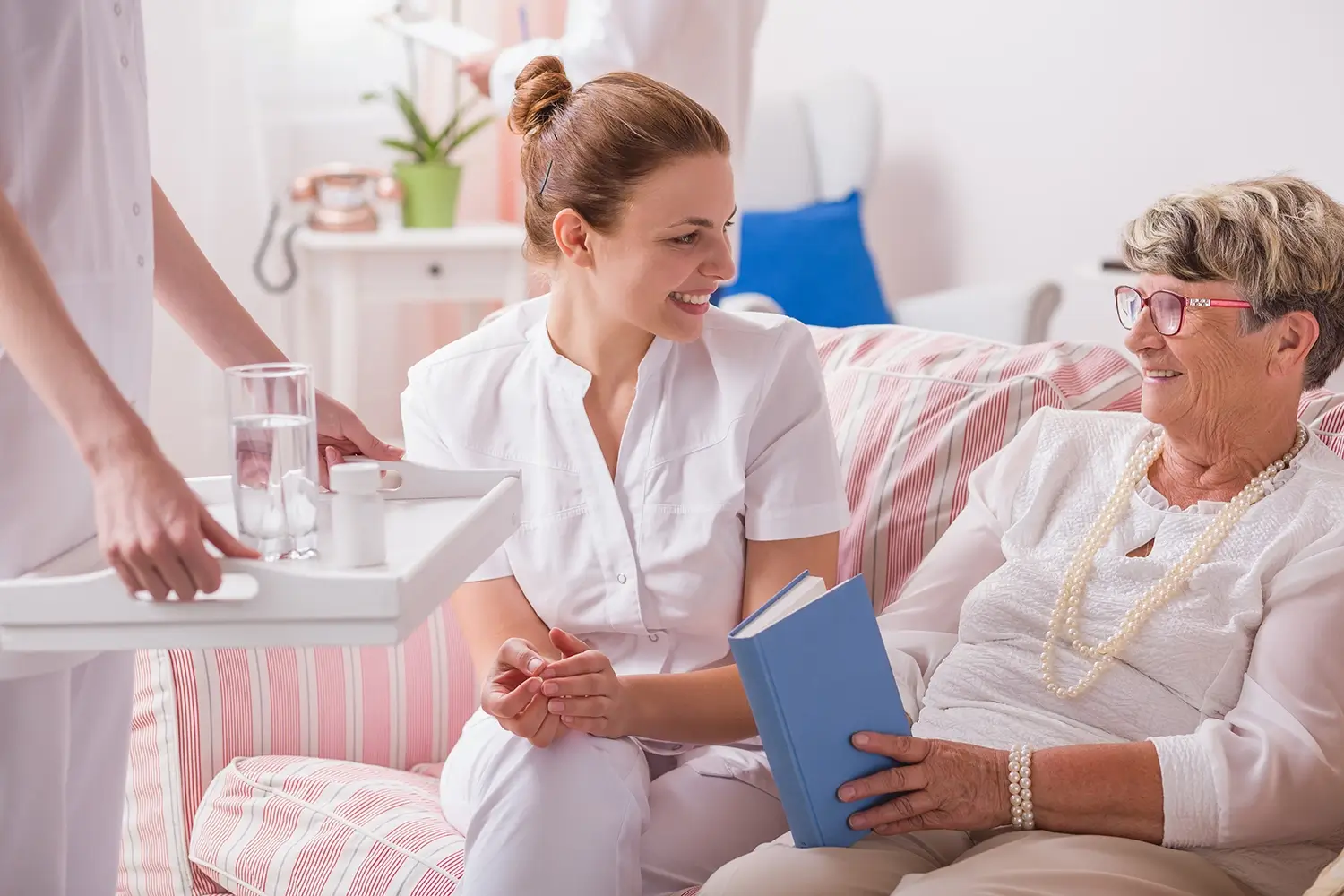 Eine lächelnde Krankenschwester spricht mit einer älteren Frau